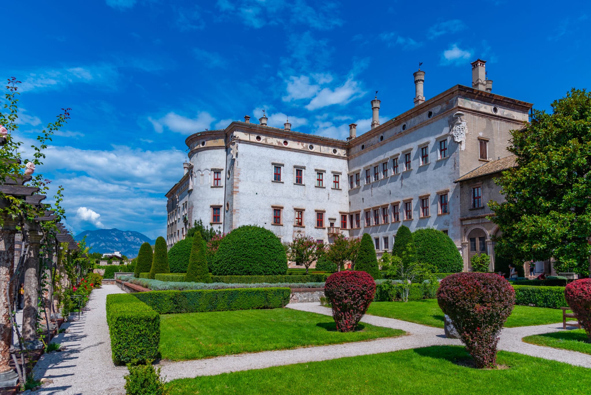 Villa storica con giardino all'italiana e cielo azzurro.