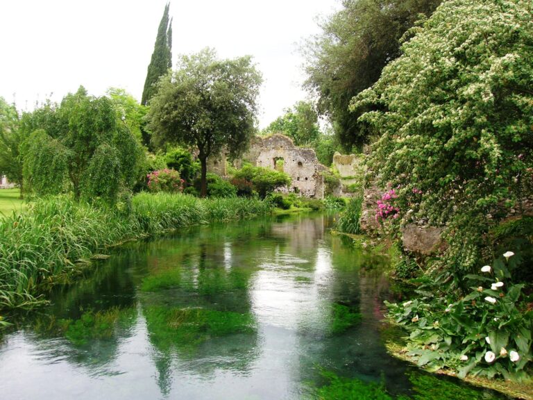 Giardino fiorito con rovine e fiume.