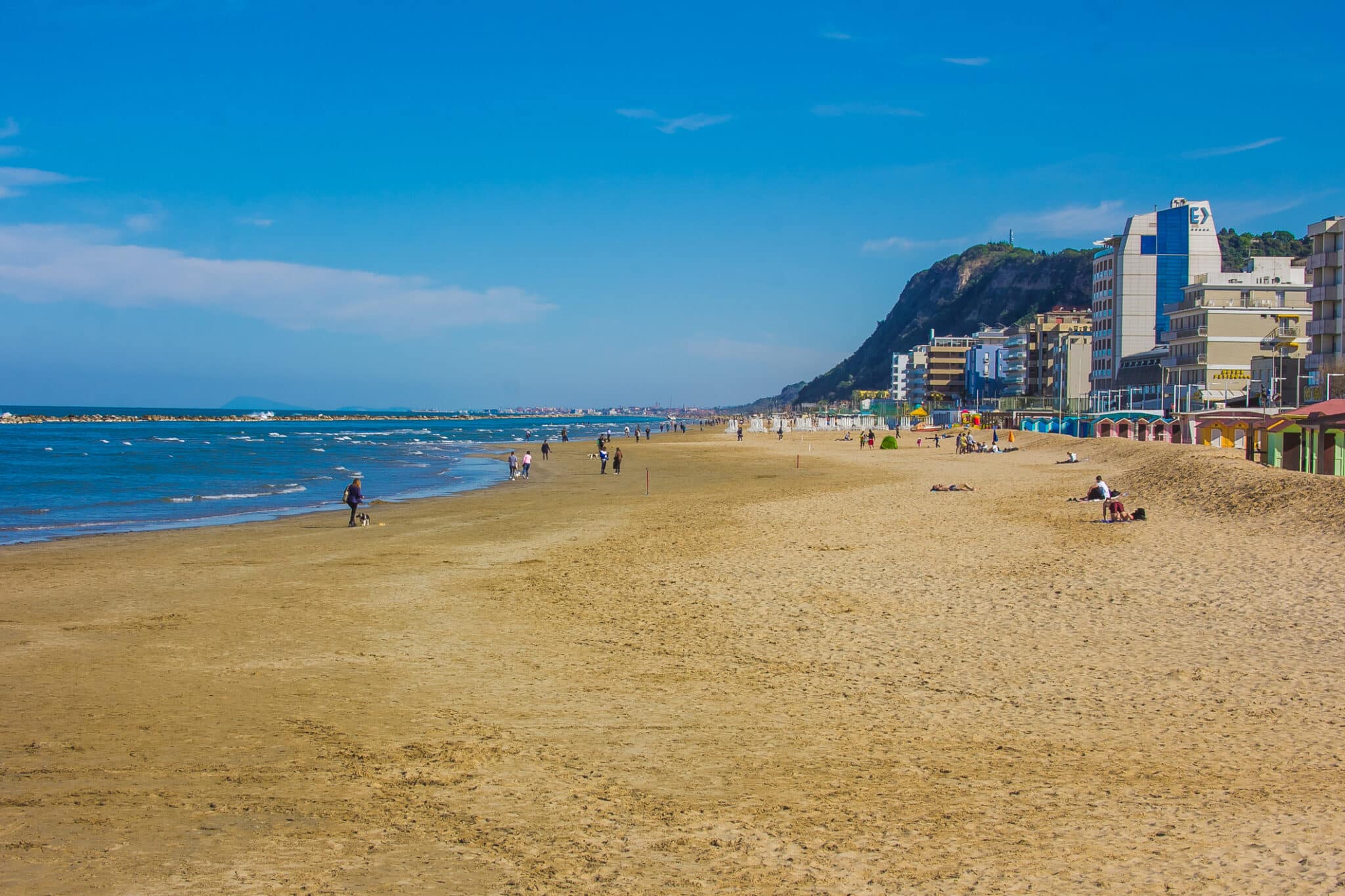 Turista che cammina sulla spiaggia di Pesaro nella stagione estiva, Marche, Italia