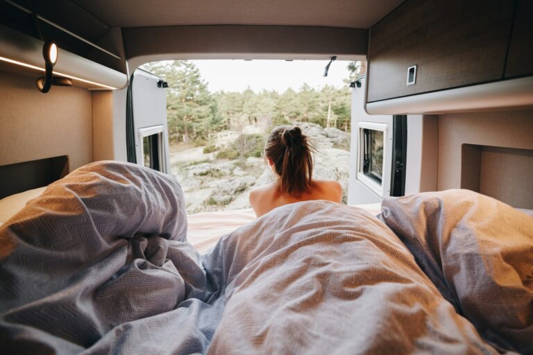 Young woman using laptop in camper