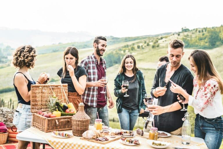 Amis adultes heureux mangeant lors d'un pique-nique dans un vignoble italien en plein air