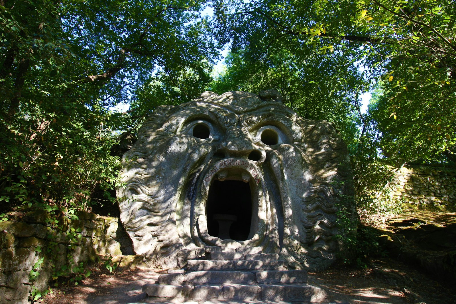 una struttura in pietra con un buco circondato da alberi a Bomarzo vicino Viterbo