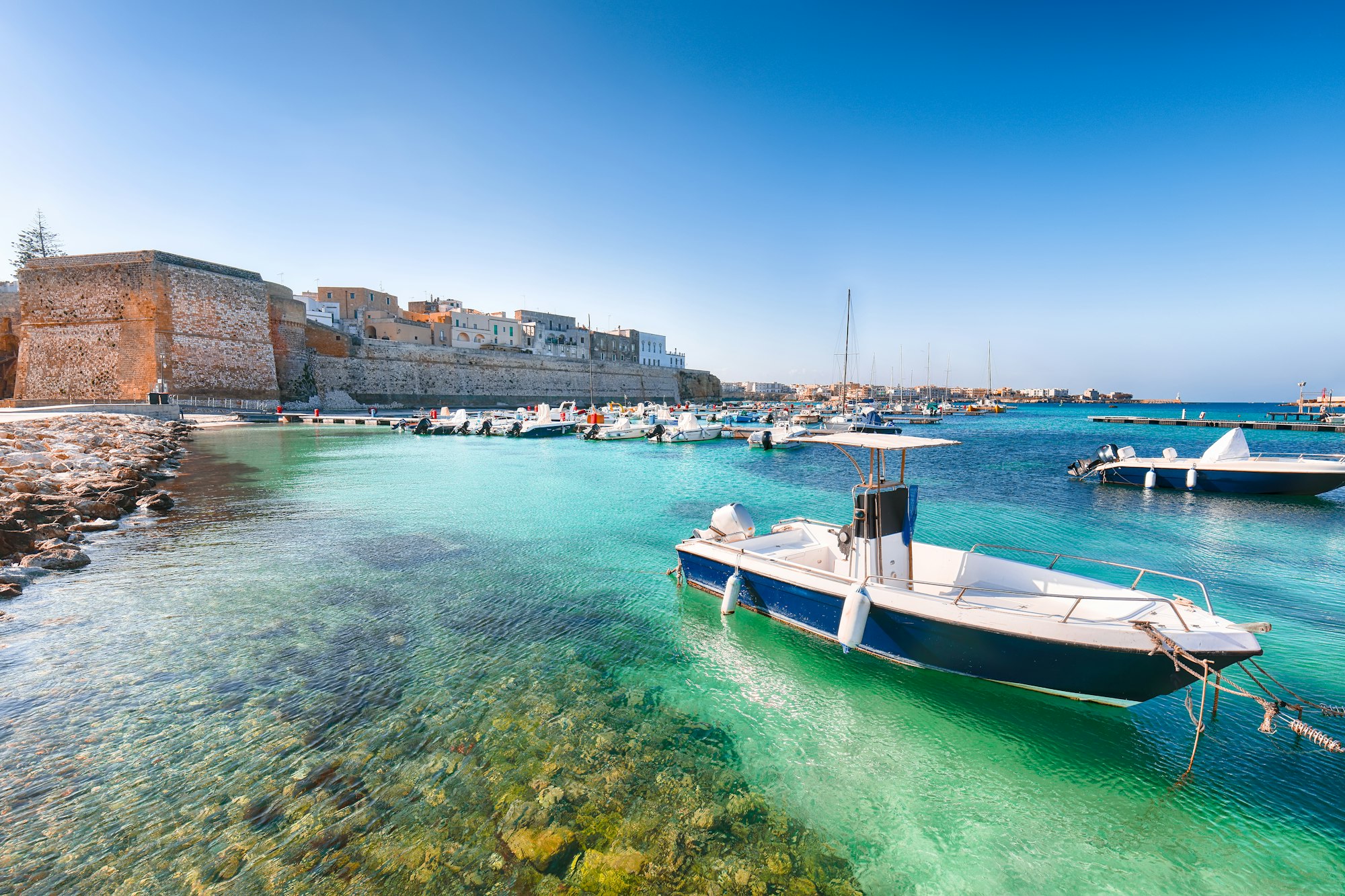 Numerose barche da pesca al porto di Otranto - città costiera della Puglia con mare turchese