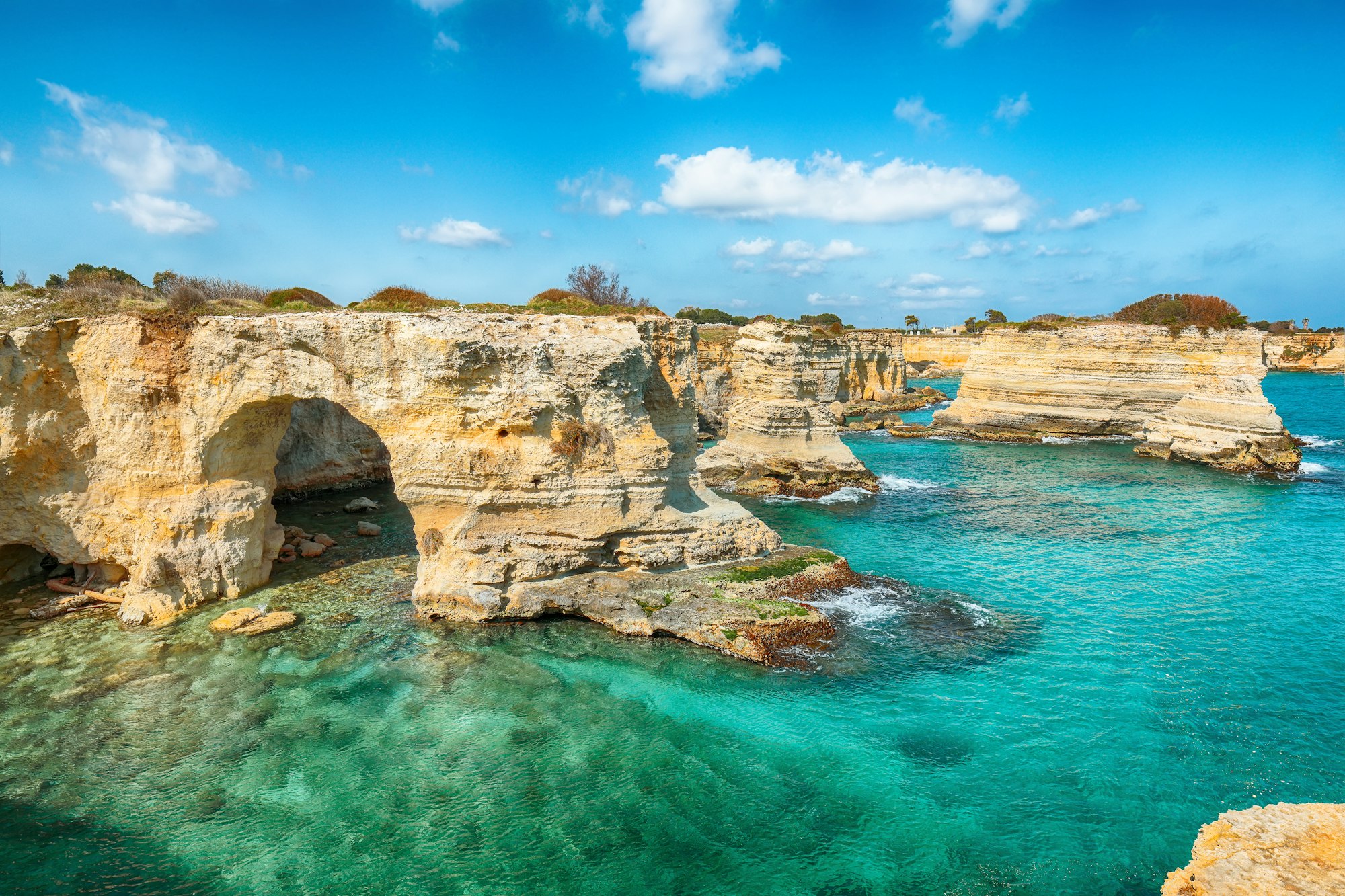 Splendida vista sul mare con scogliere, arco roccioso e faraglioni (faraglioni) a Torre Sant'Andrea