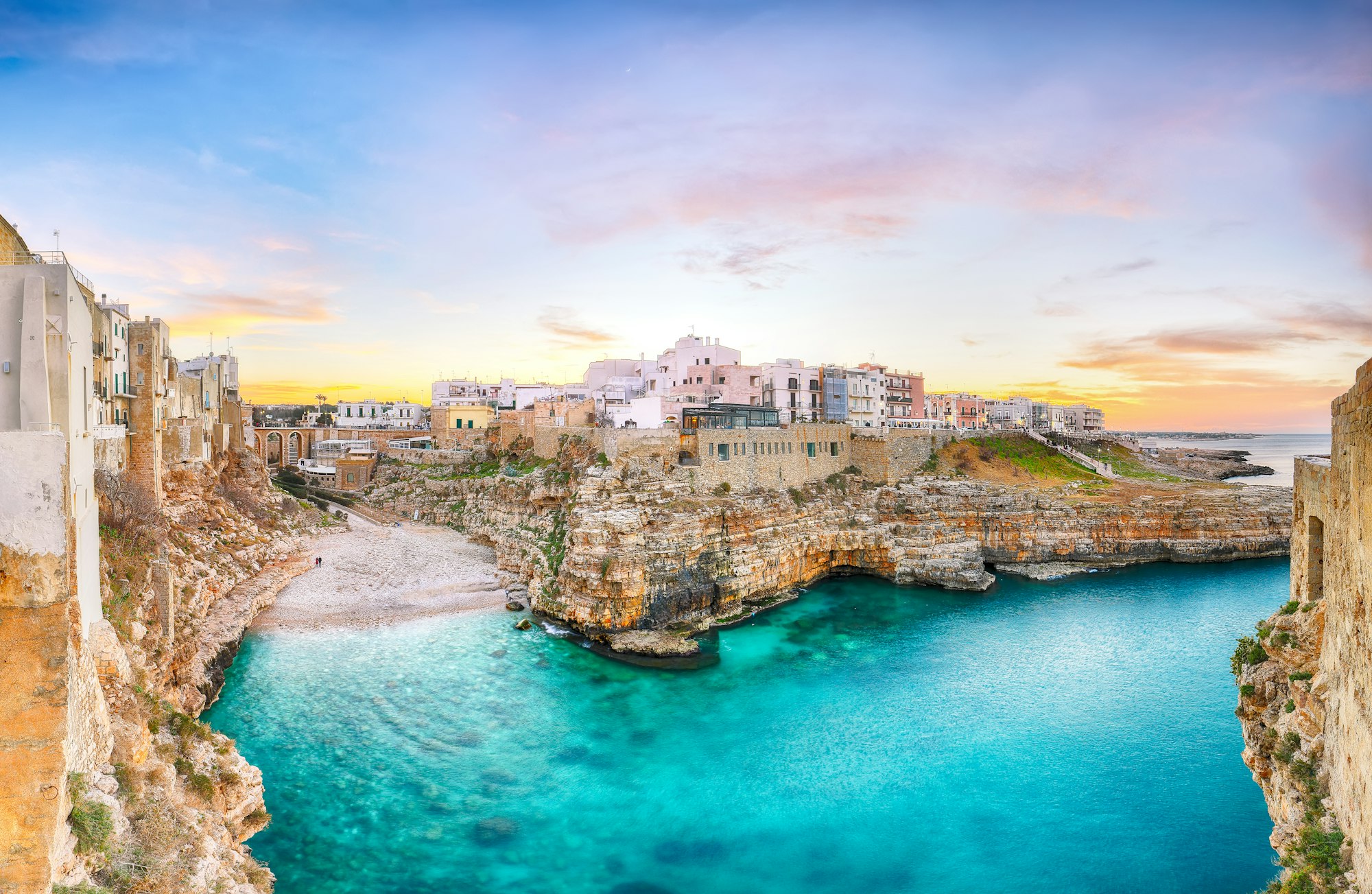 Beautiful sunset over the Gulf of Cala Paura with the Bastion of Santo Stefano and Lama Monachile beach