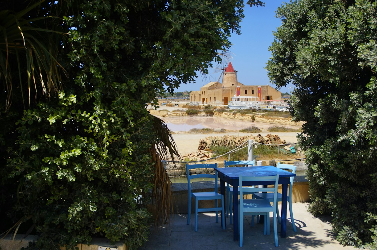 blue plastic table and chairs on the beach during the day