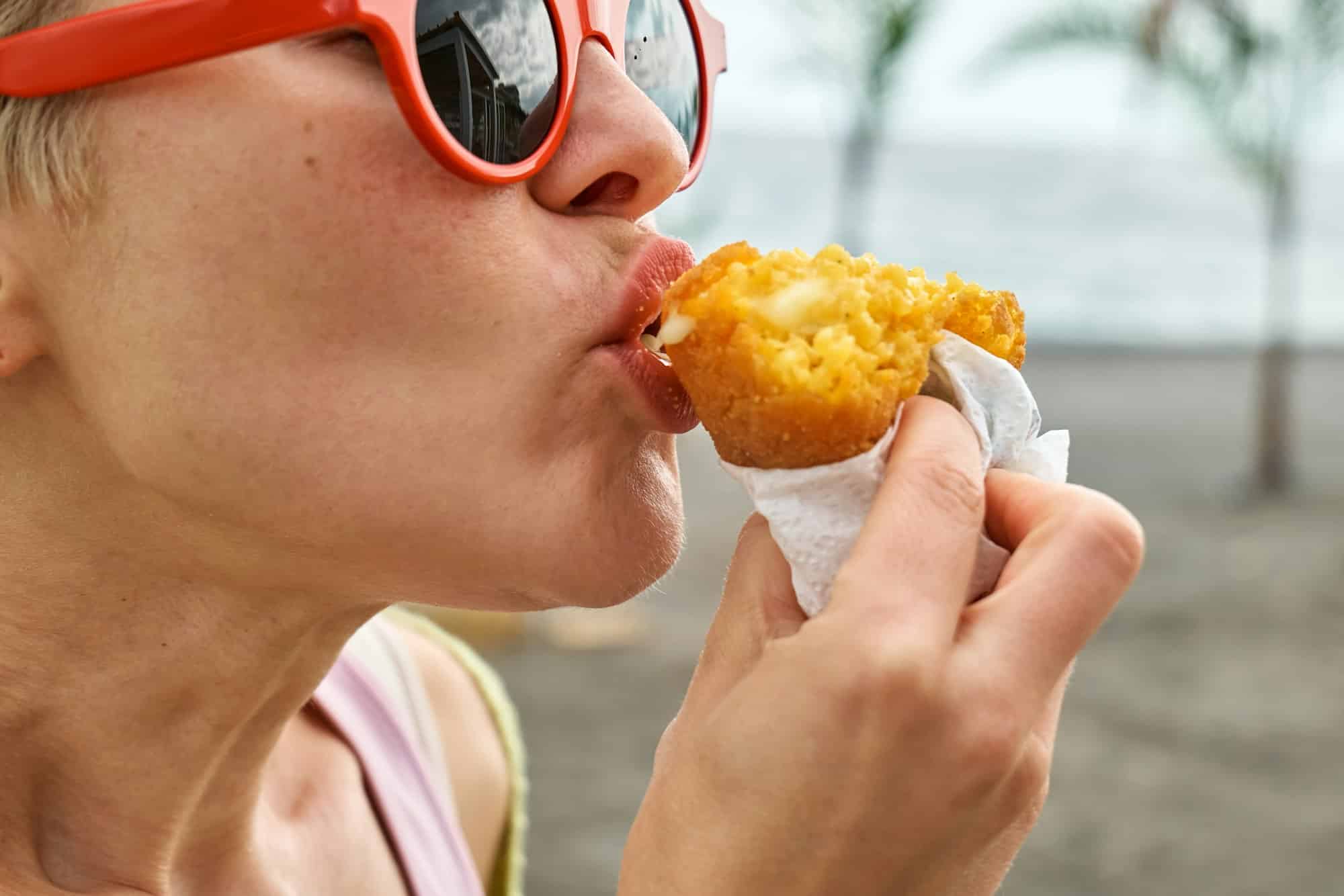 Ragazza che mangia un Arancino a Palermo