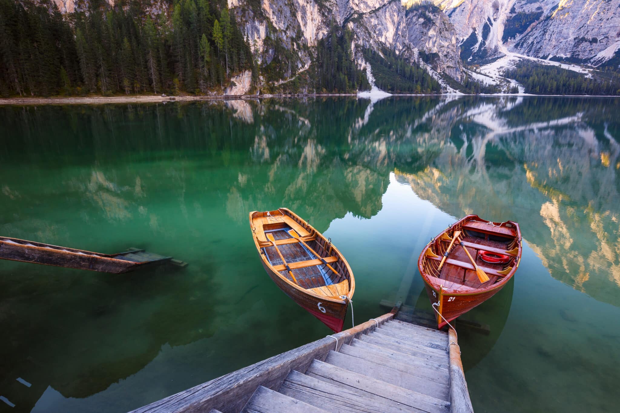 Barche legno su lago alpino tranquillo.