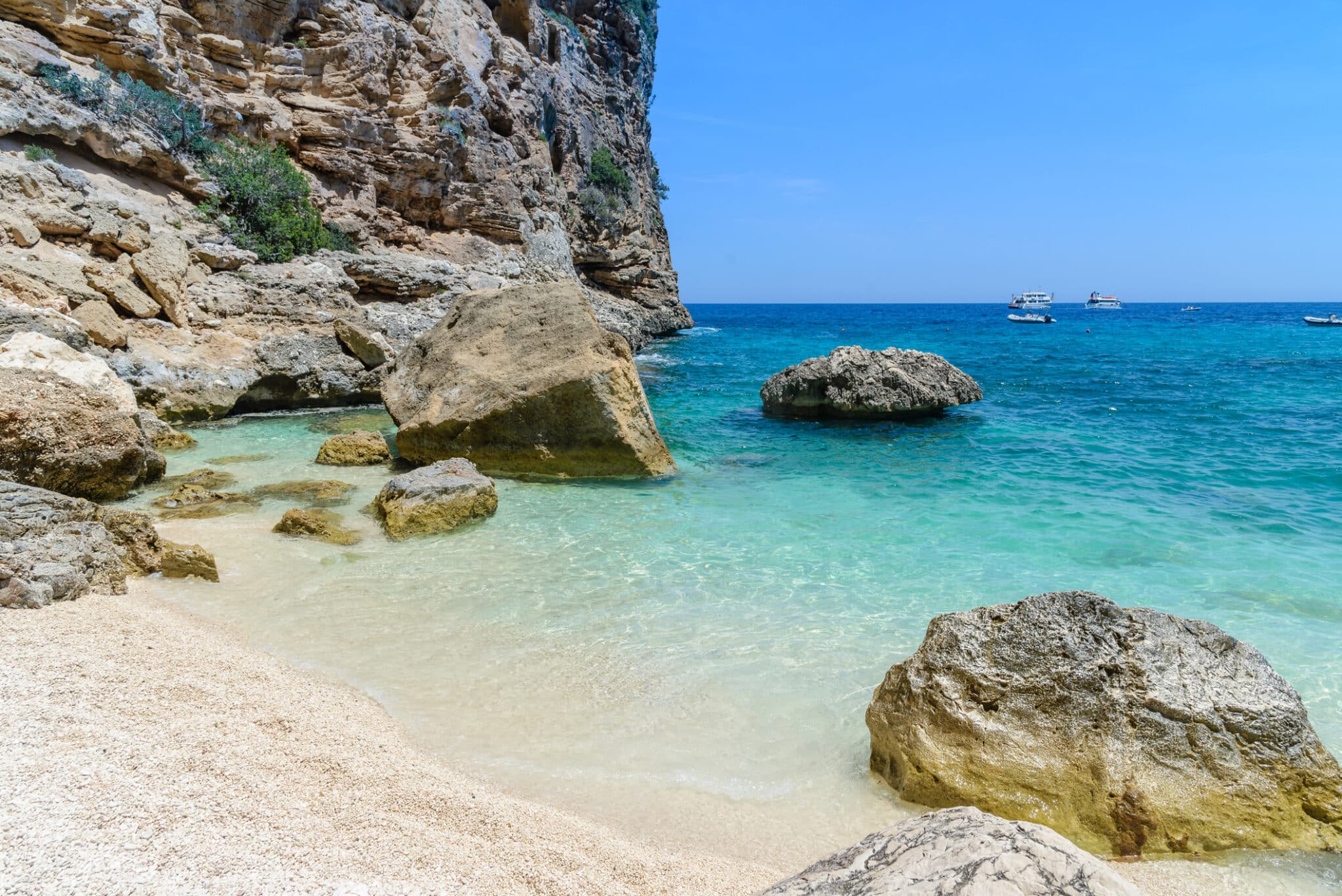 Spiaggia rocciosa con mare cristallino.