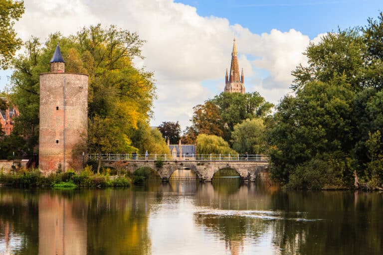 Paysage fluvial avec tour médiévale et cathédrale.