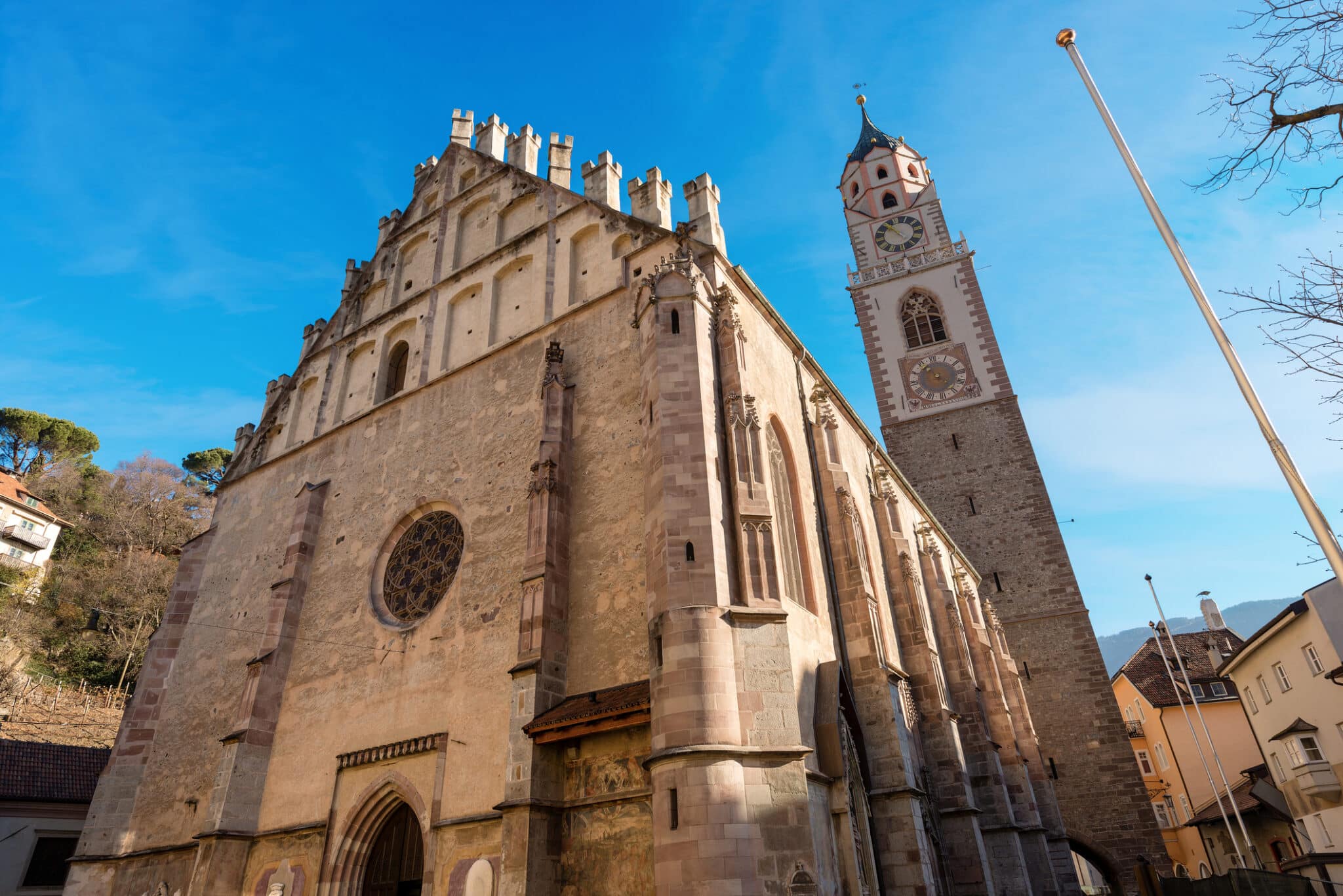 Duomo gotico con torre campanaria e cielo azzurro.