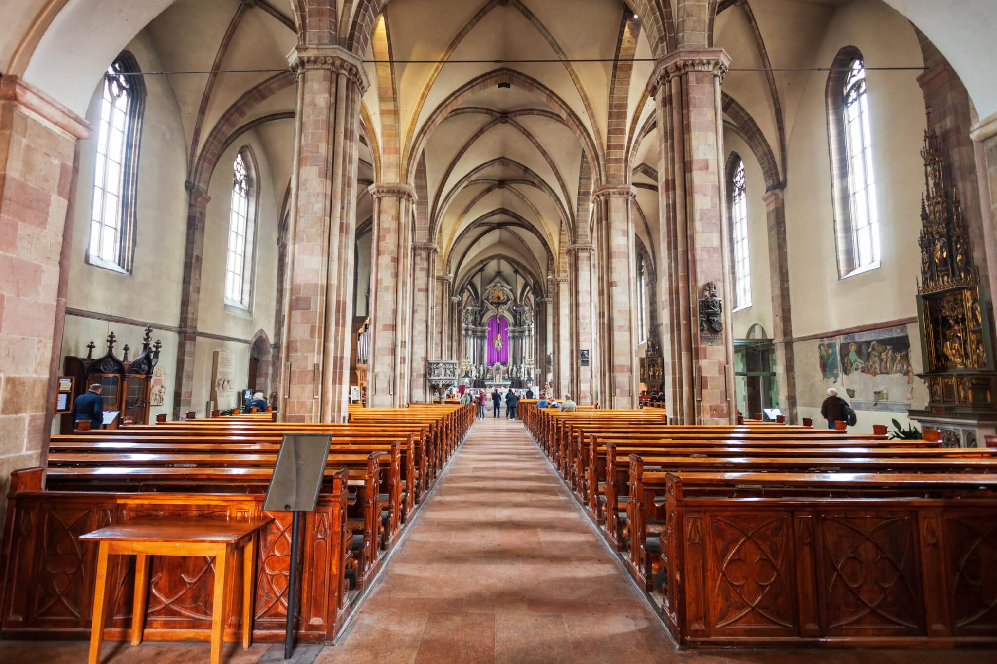 Interno chiesa gotica con banchi in legno.