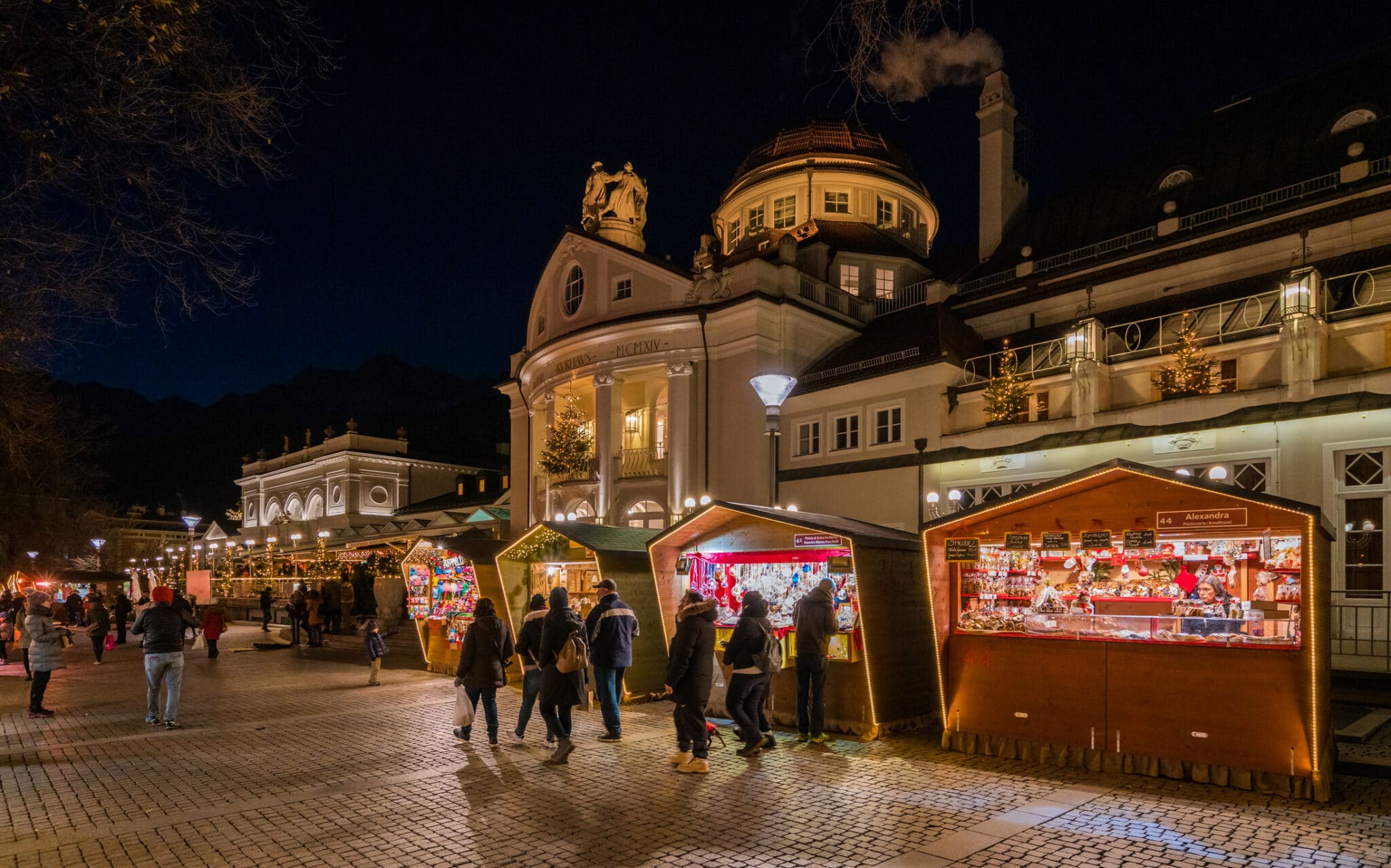 Mercatino natalizio serale in città europea.