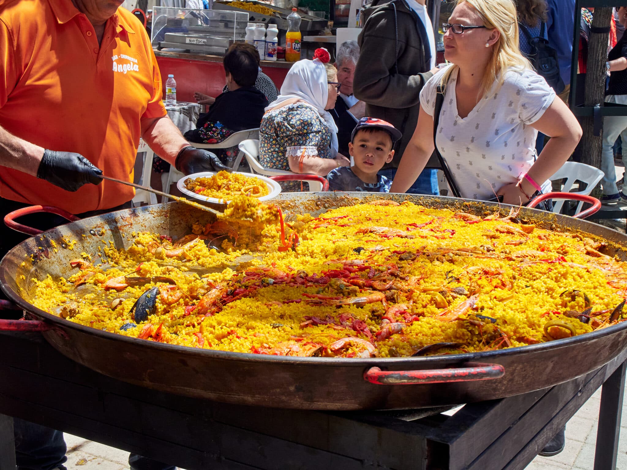 Grande padella di paella colorata in evento all'aperto.