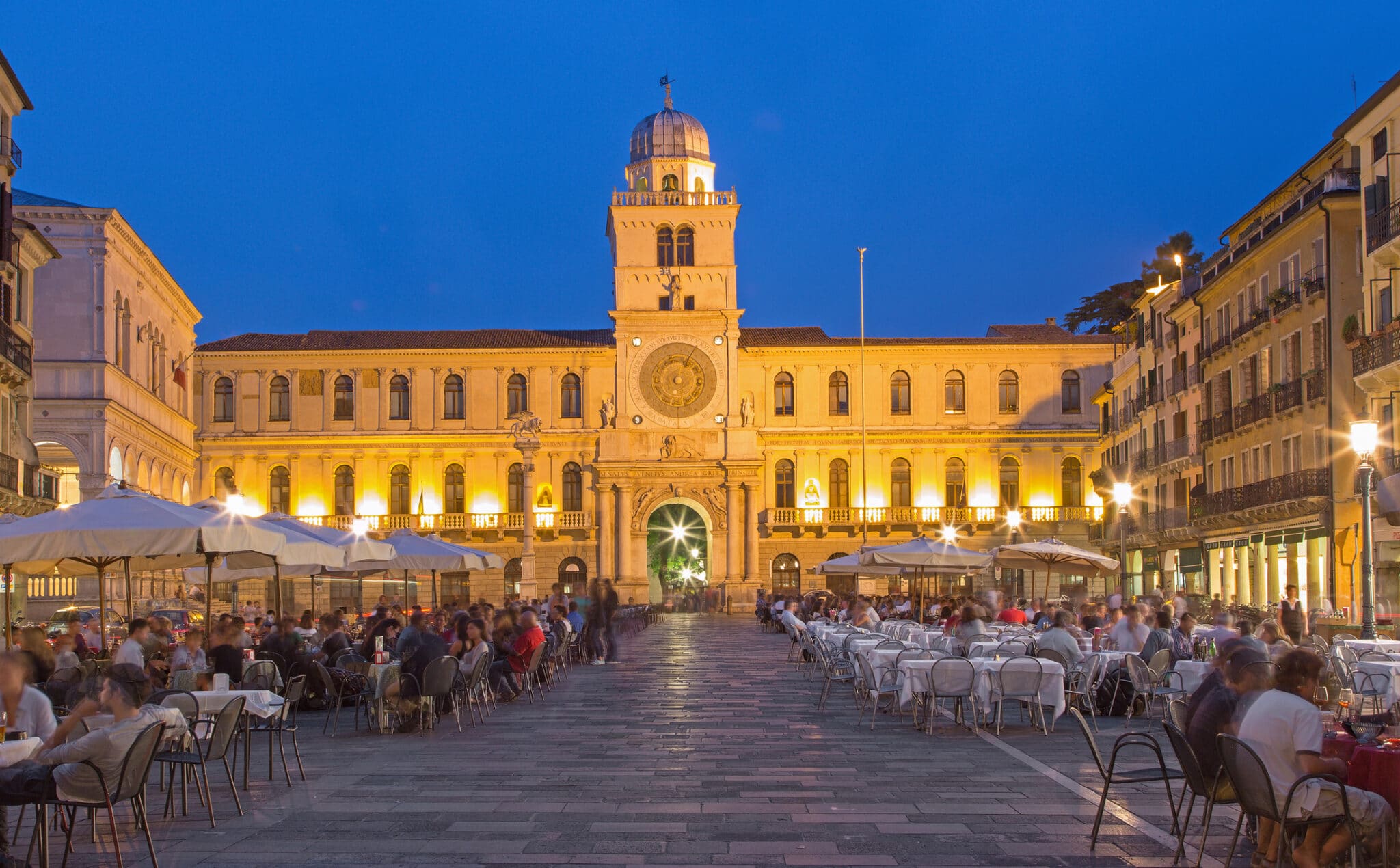 Piazza italiana con caffè serale e architettura storica