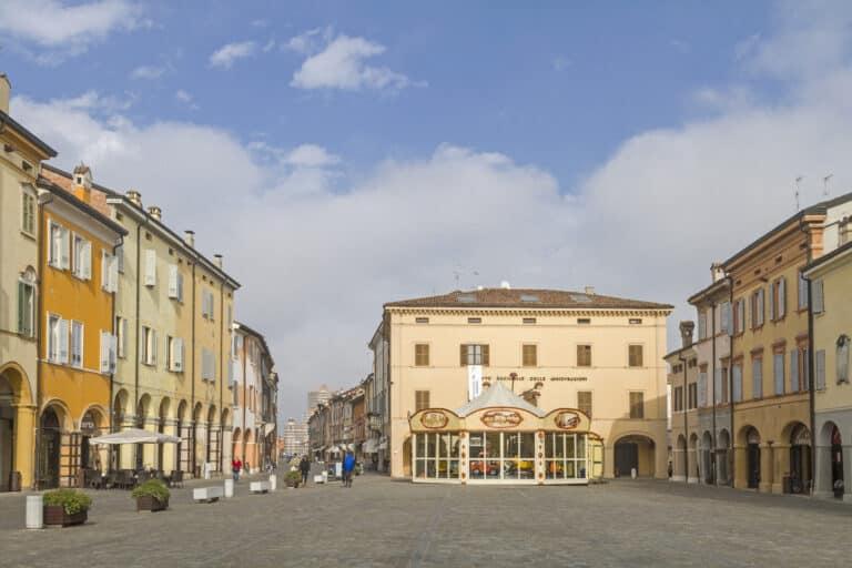 Piazza italiana con edifici colorati e cielo azzurro.