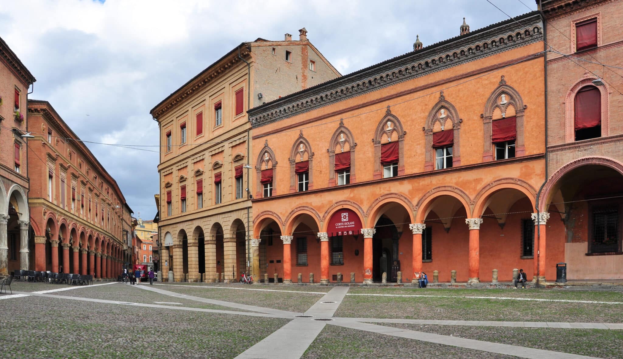 Place italienne avec des arcades architecturales et des gens.