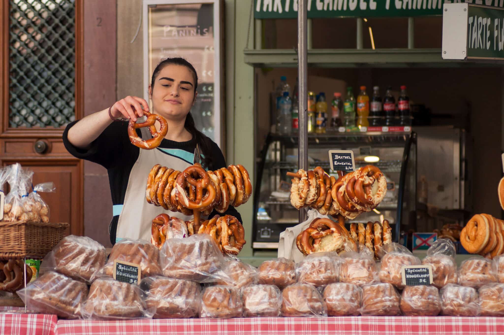 Venditrice con bretzel al mercato.