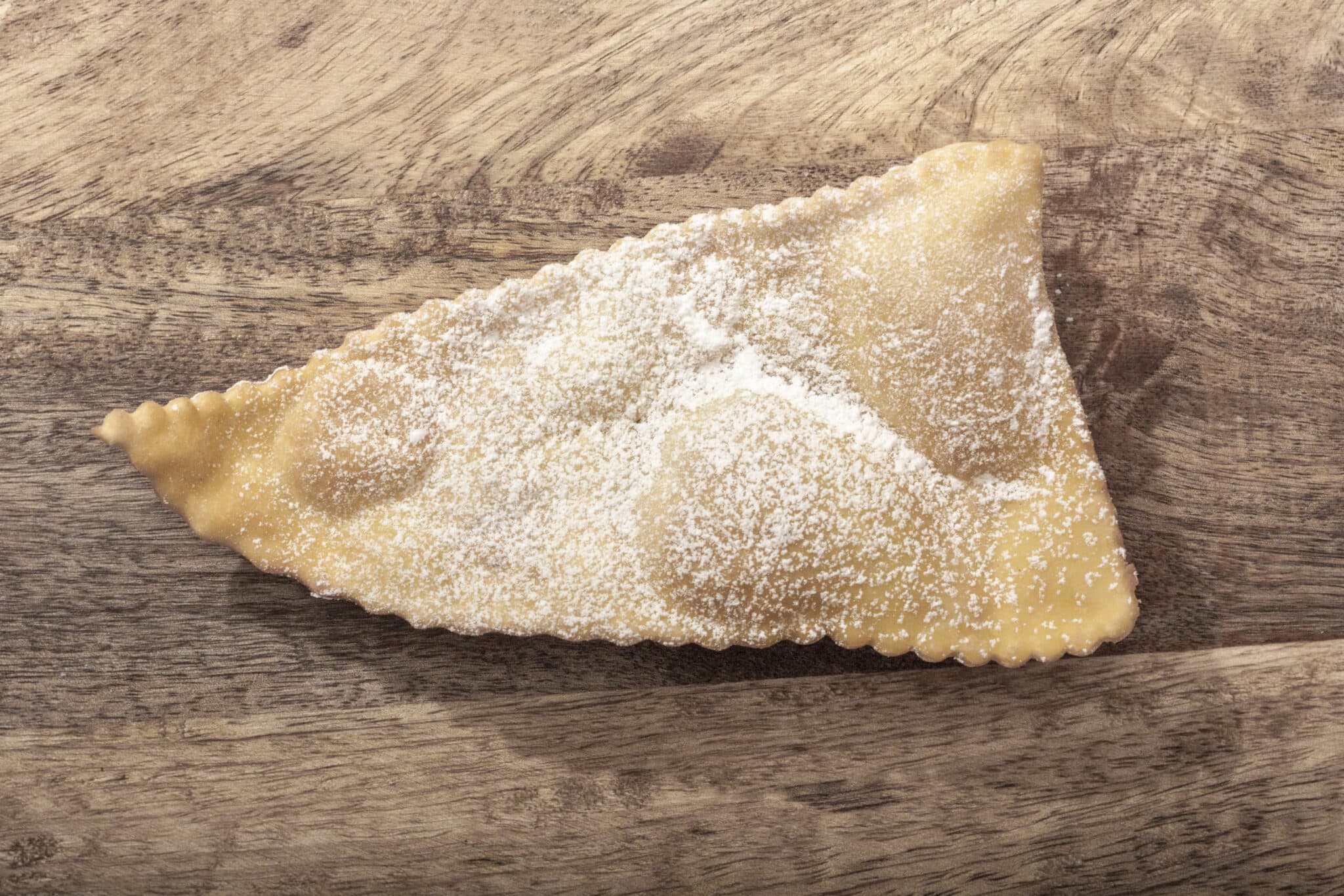 Triangolo di pasta ripiena su legno.