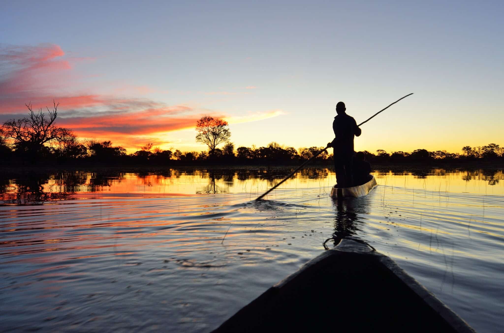 Saling nel delta di Okavango al tramonto, Botswana