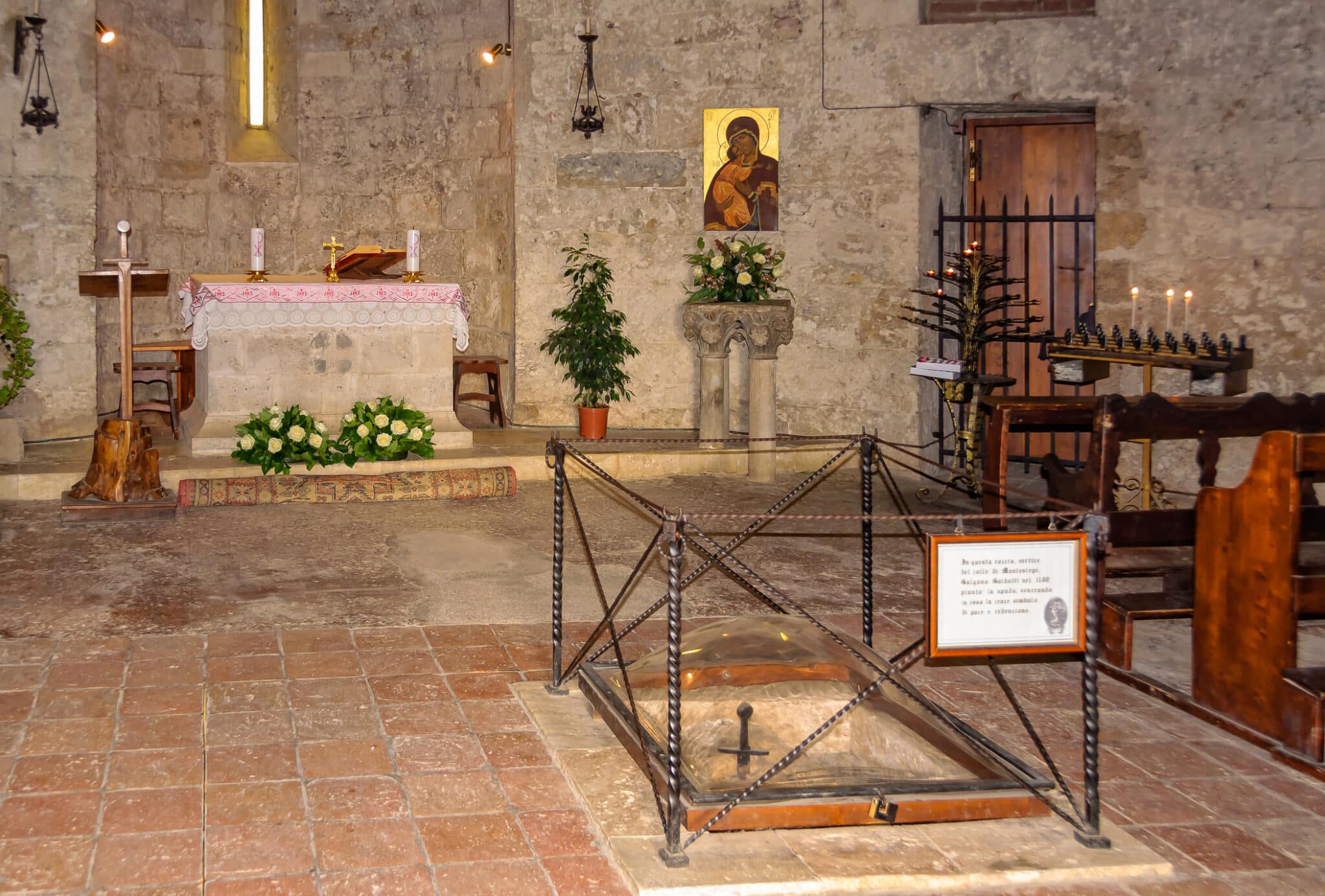 Old church altar with icon and lighted candles.