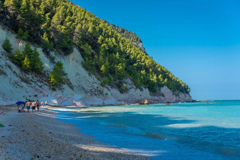 Plage avec des gens et une mer cristalline.