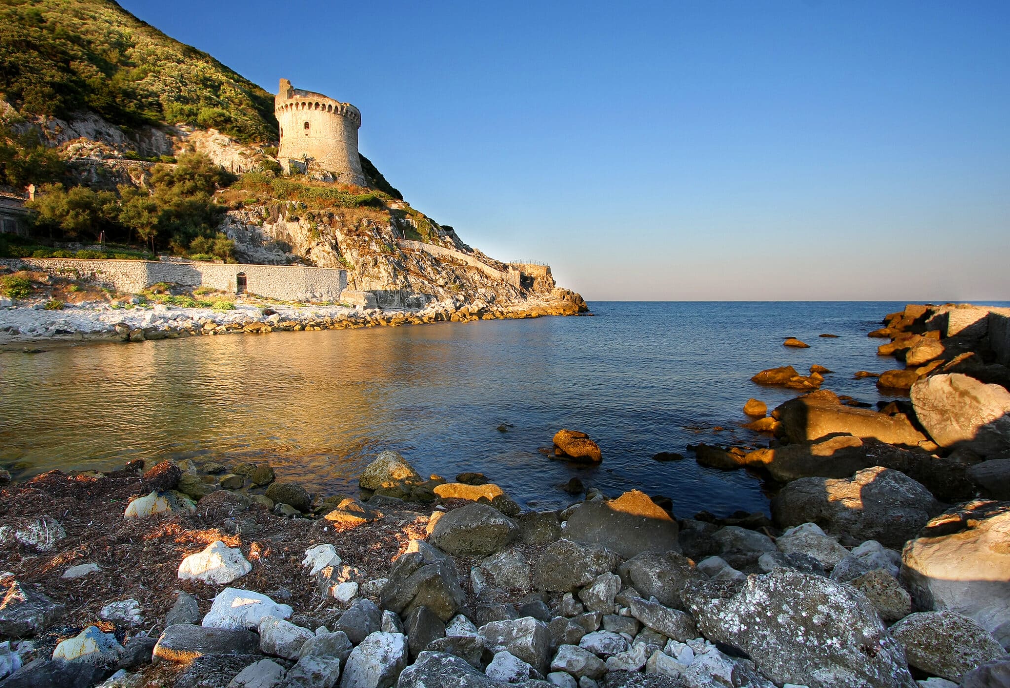 Torre medievale su costiera rocciosa al tramonto