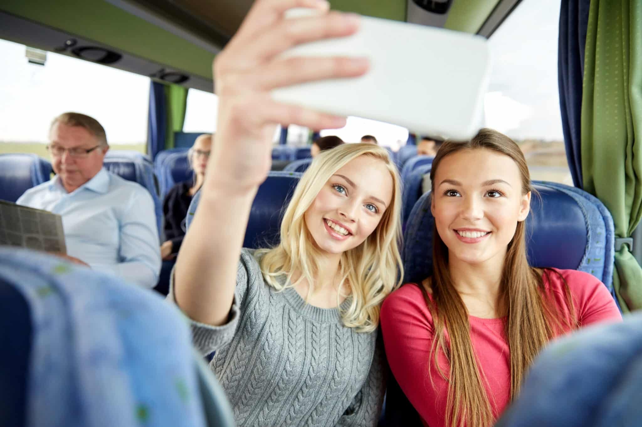 Deux filles prennent un selfie dans le bus.