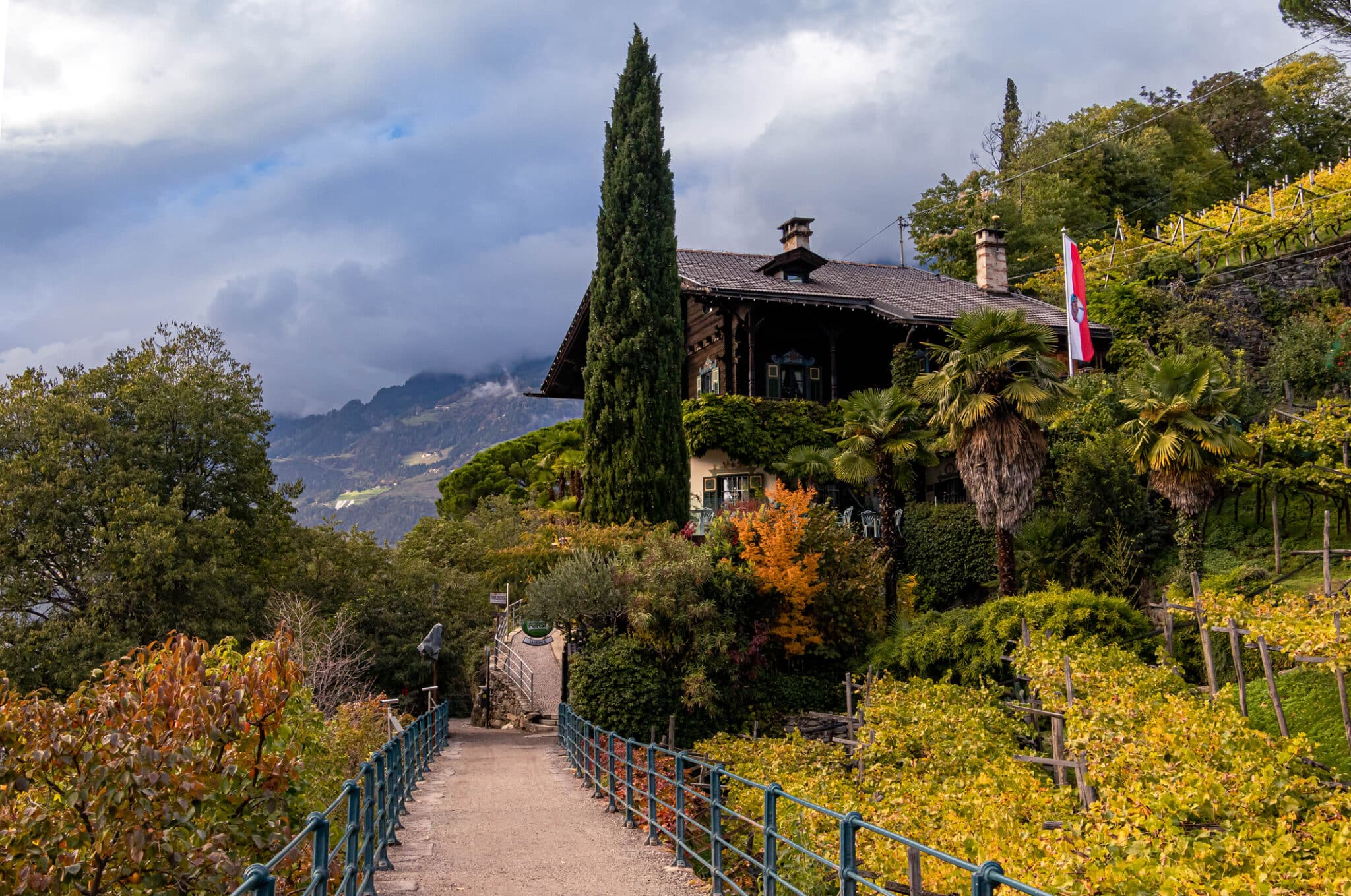 Villa autunnale con giardino e montagne nuvolose.