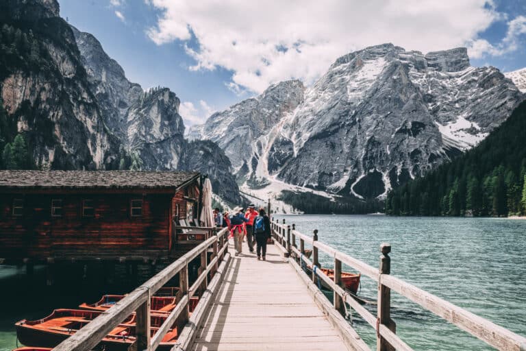 Ponte in legno sul lago montano con persone.