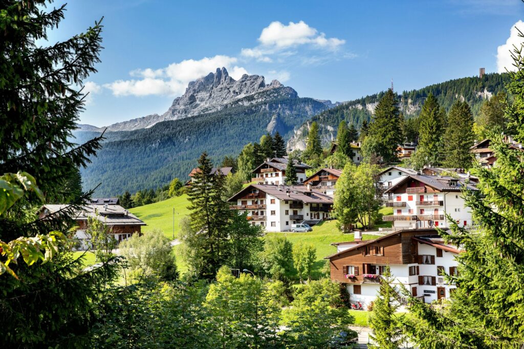 Scenic view of Cortina d'Ampezzo Dolomites town on ahill wit green trees and mountainous landscape