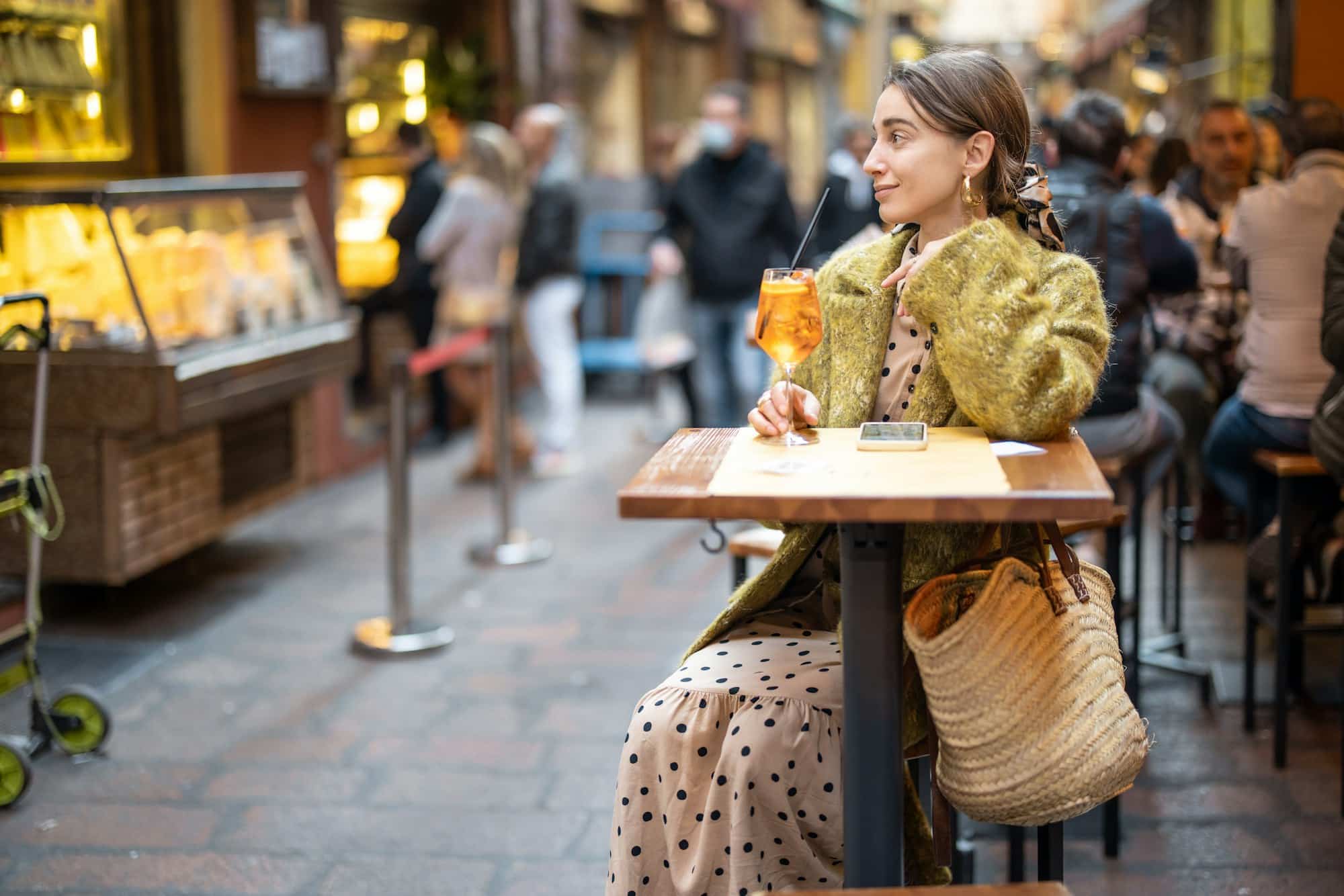 Ragazza che prende un cocktail nelle vie del centro di Bologna