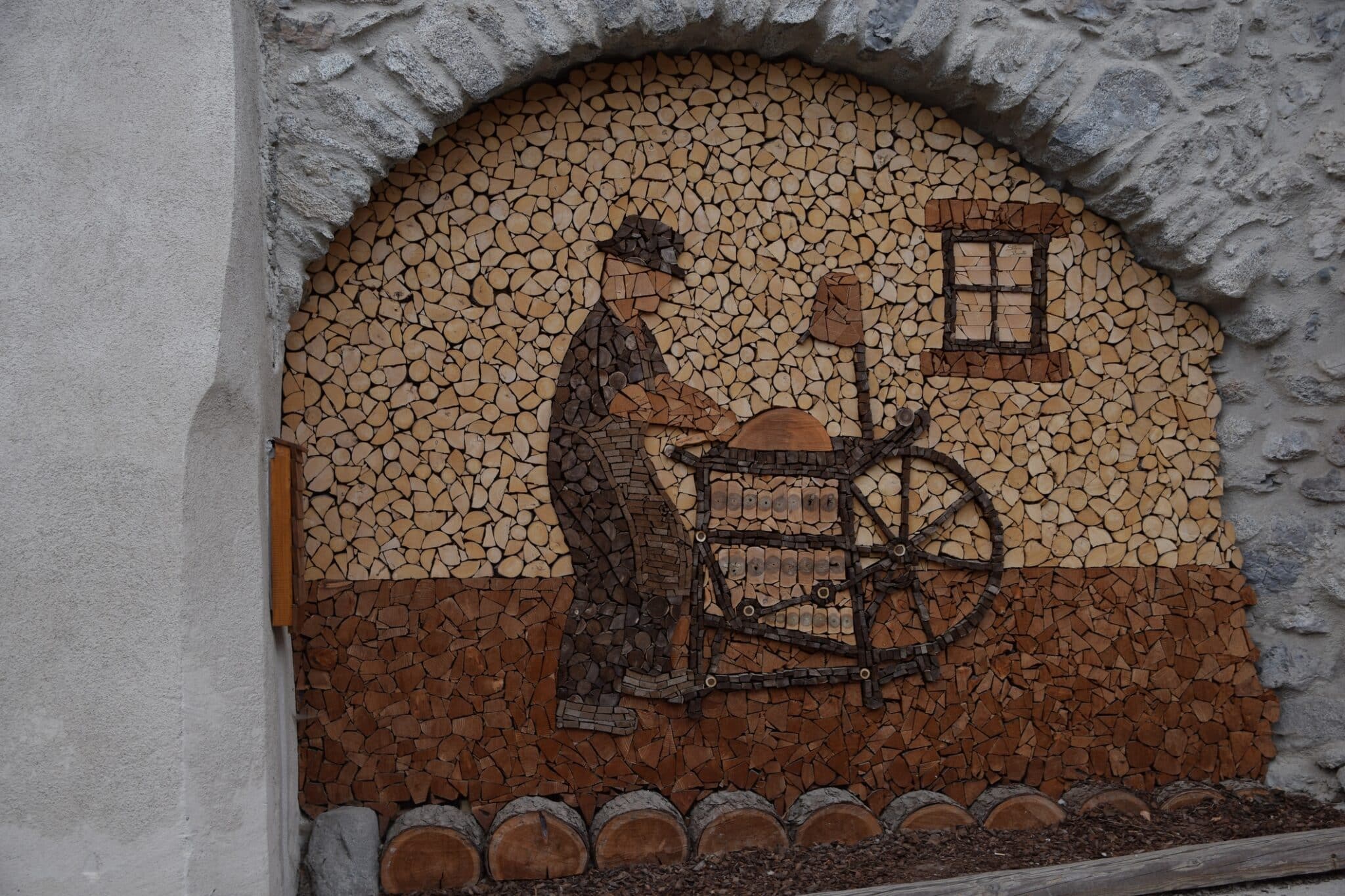 Scultura in legno nel centro storico del borgo di Rango Trentino, selezionato uno dei borghi più belli d'Italia. con le sue caratteristiche case in pietra,porte finestre