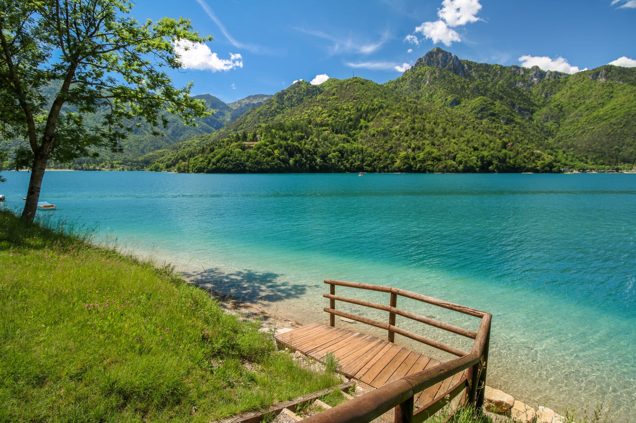 Una bellissima vista sul lago del Lago di Ledro in Italia, Europa con acque limpide e alberi soleggiati