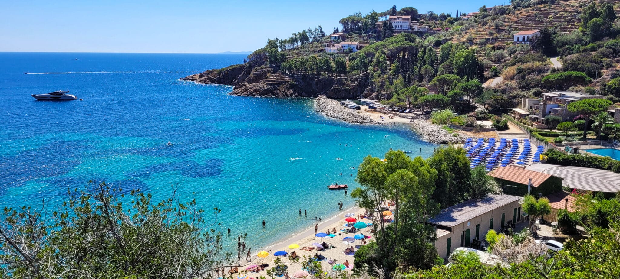 spettacolare vista mare sull'Isola del Giglio. Alcune barche si muovono sul mare in una giornata soleggiata