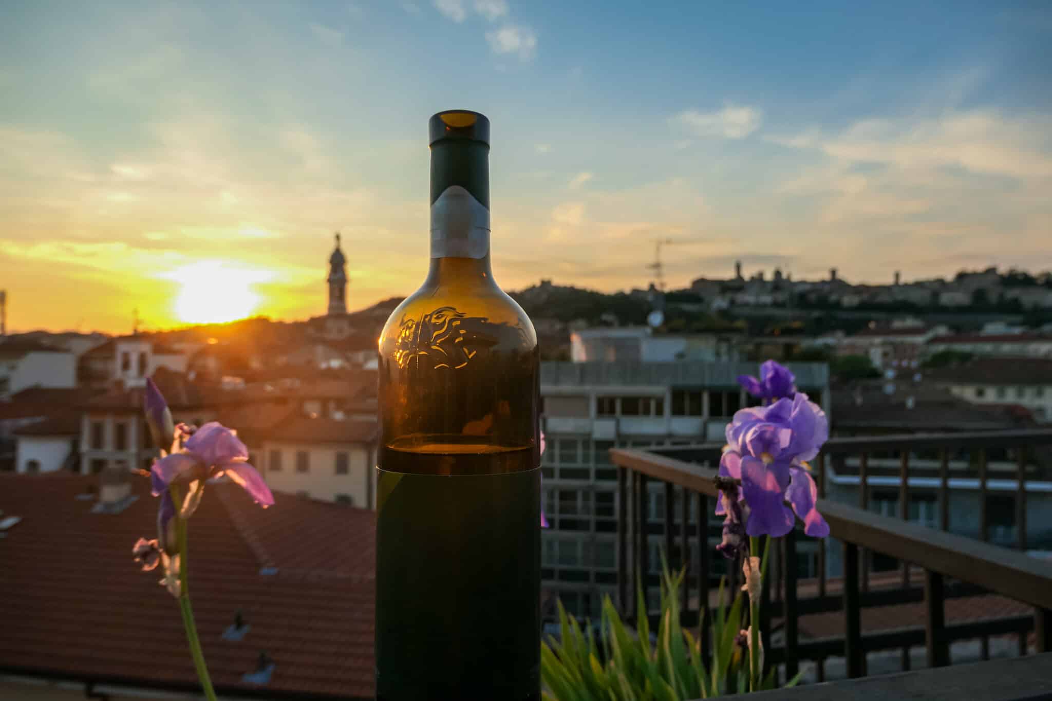 Bottiglia di vino e tramonto in città.