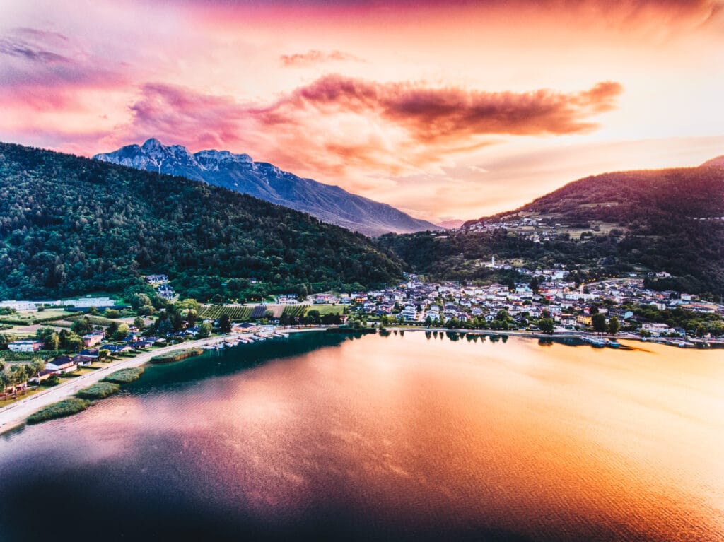 Coucher de soleil éclatant sur un lac et des montagnes.