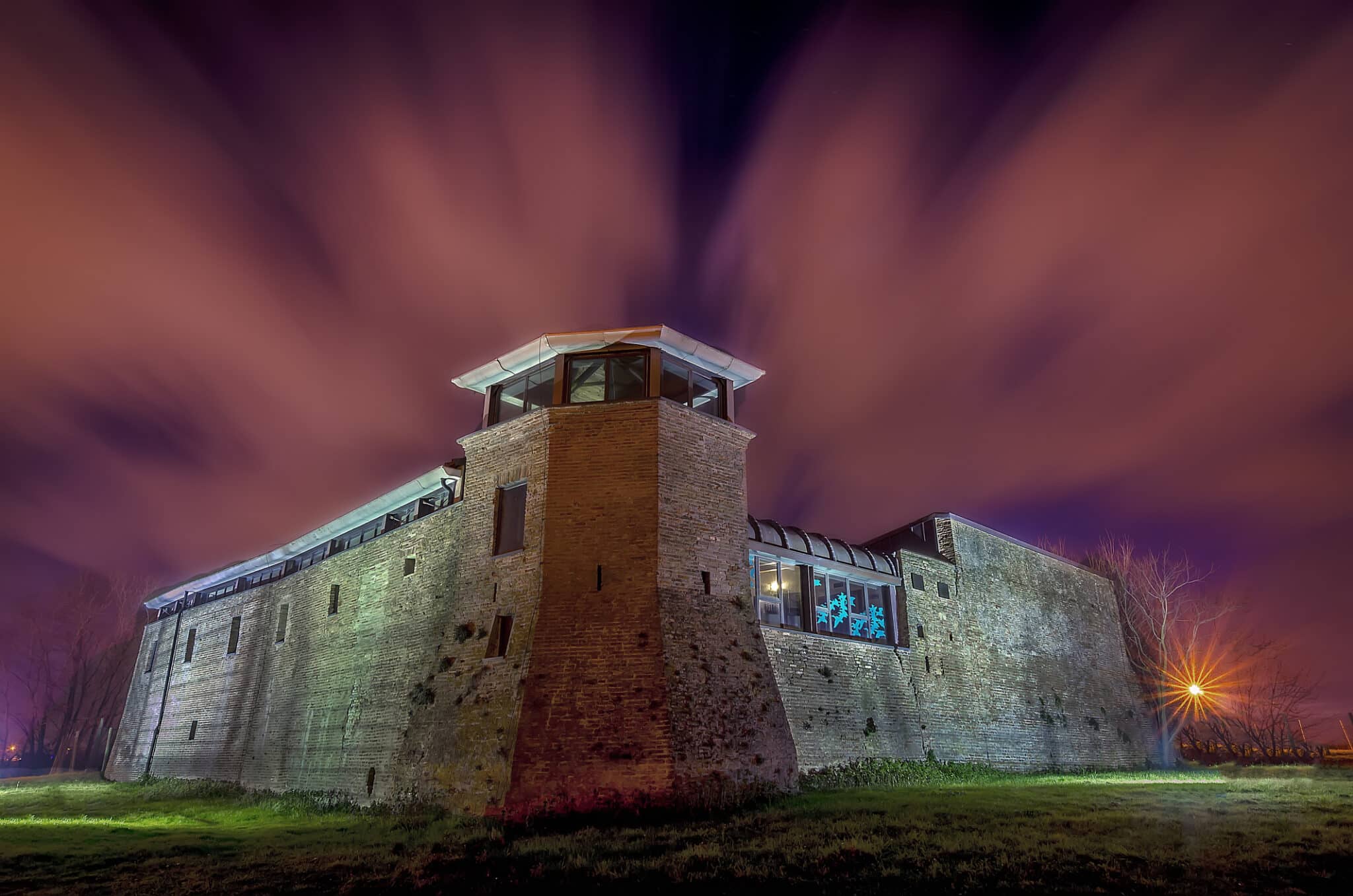 Château médiéval illuminé la nuit.