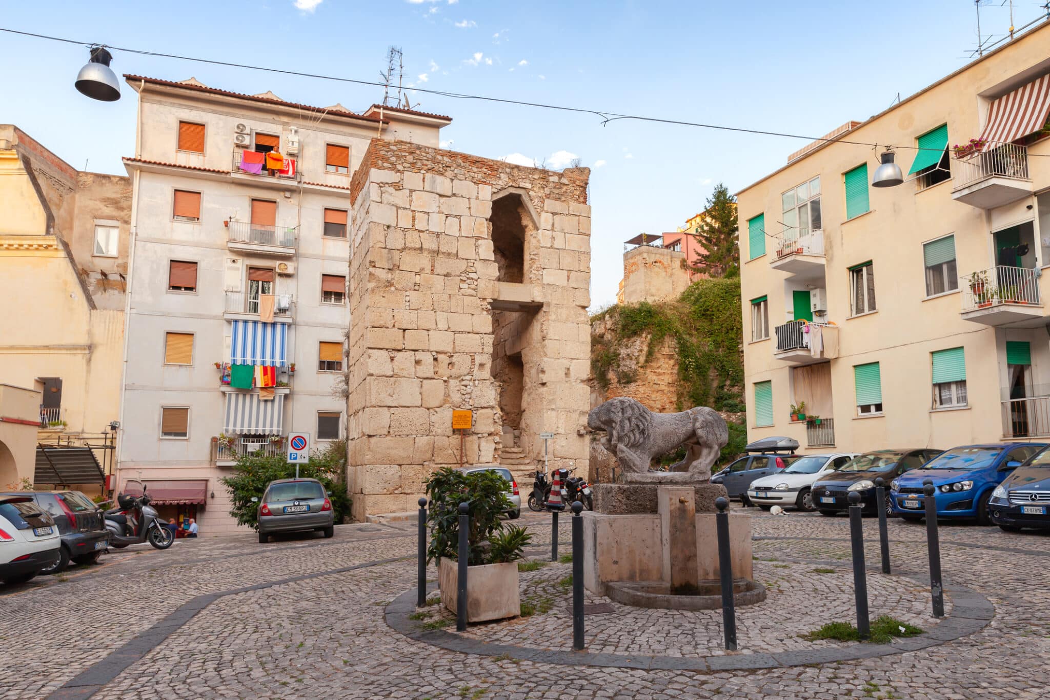 Gaetas historisches Zentrum, Straßenansicht mit alten Häusern und Löwendenkmal im Sommer