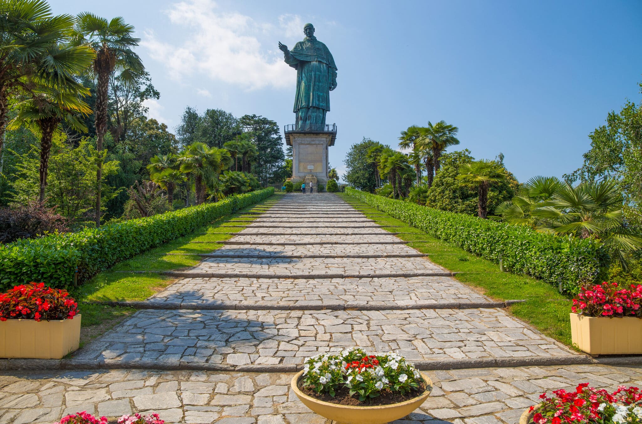 Statue historique sur fond de ciel et de jardin.