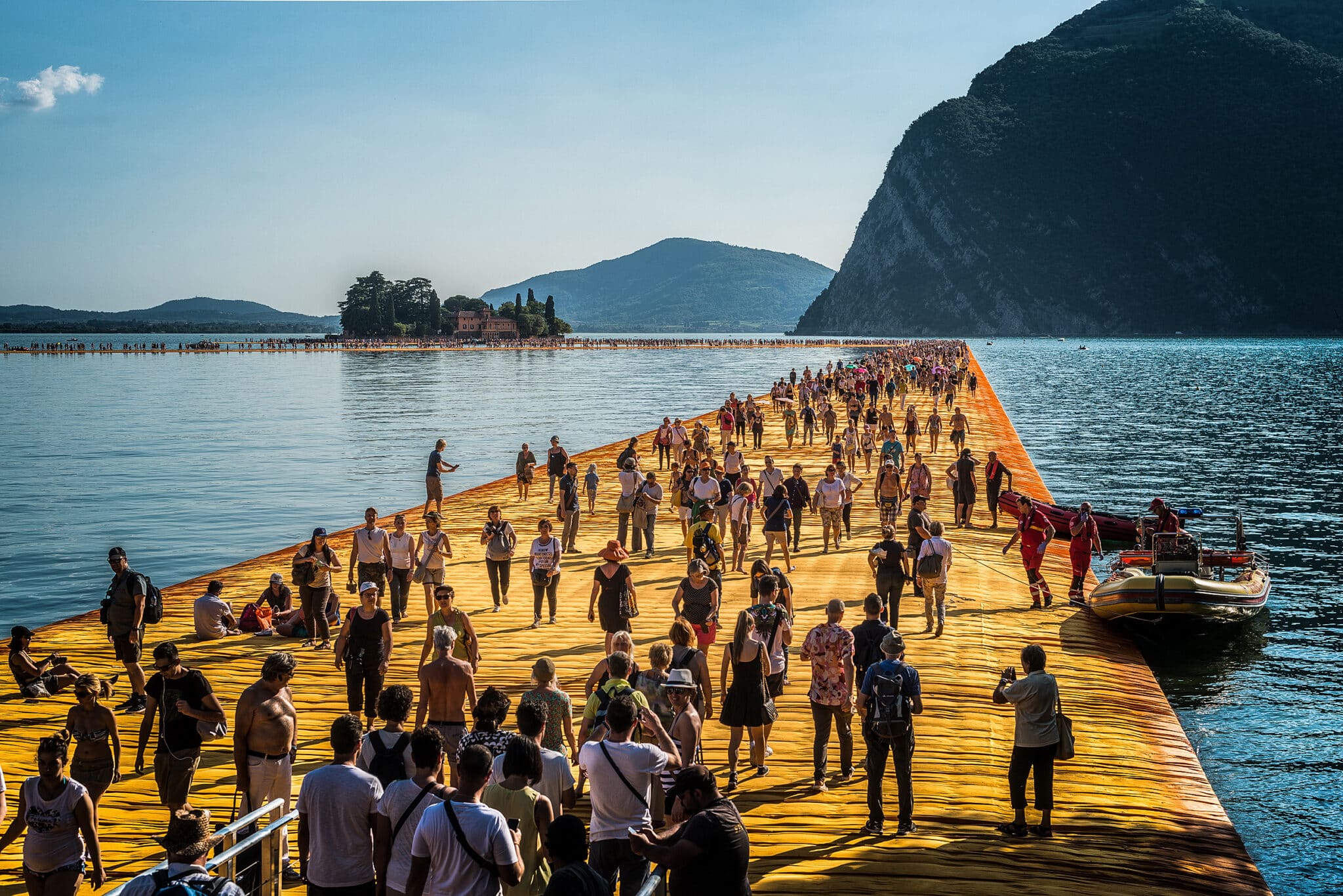 Promenade flottante sur le lac, nombreuses personnes présentes.