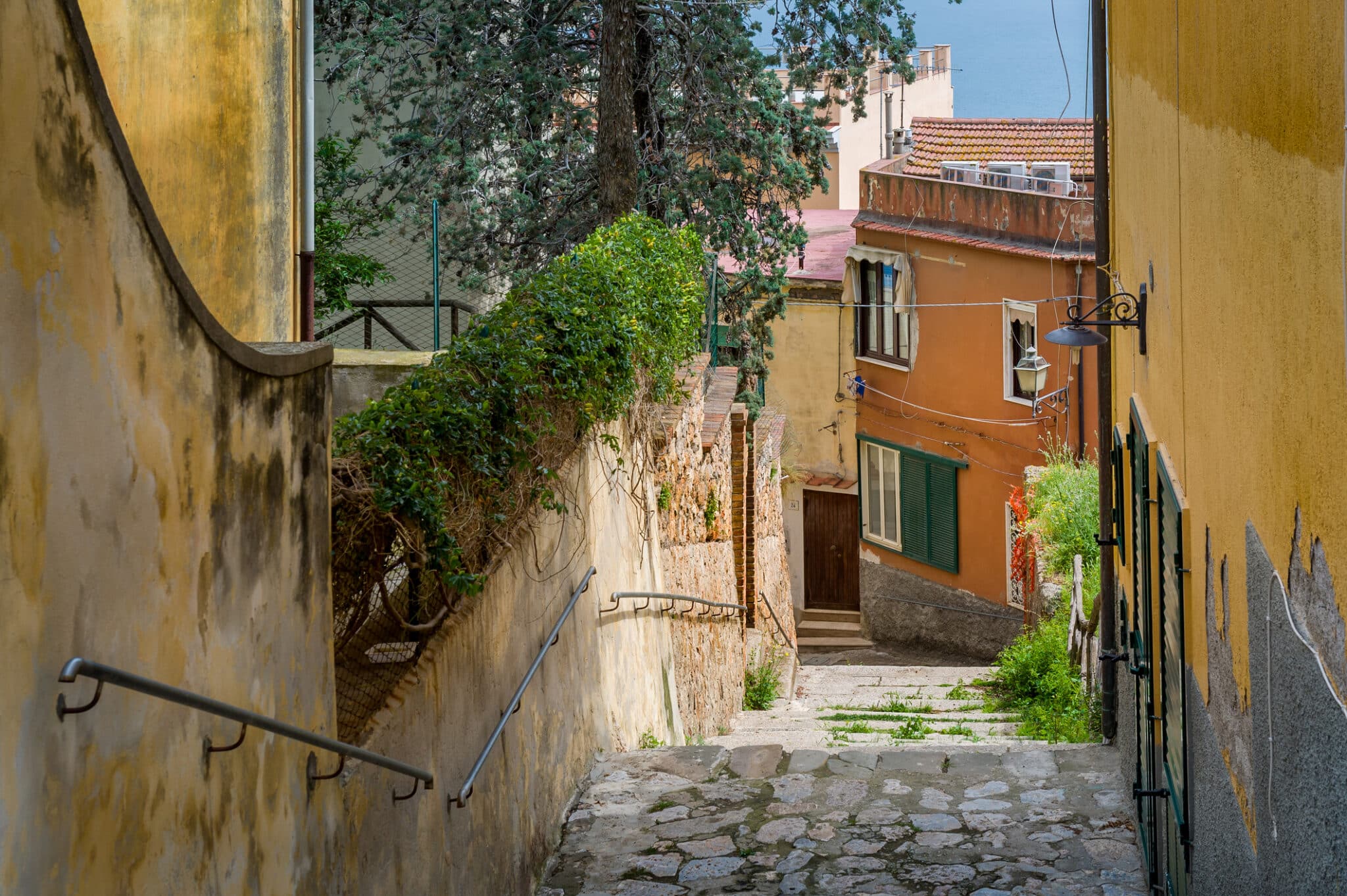 Rue avec escaliers et maisons colorées en direction de la mer.