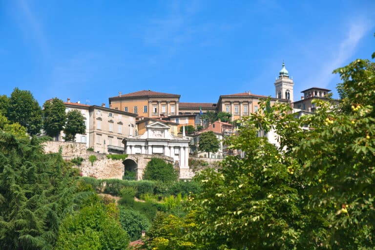 Vue de bâtiments historiques sur une colline, ciel bleu.