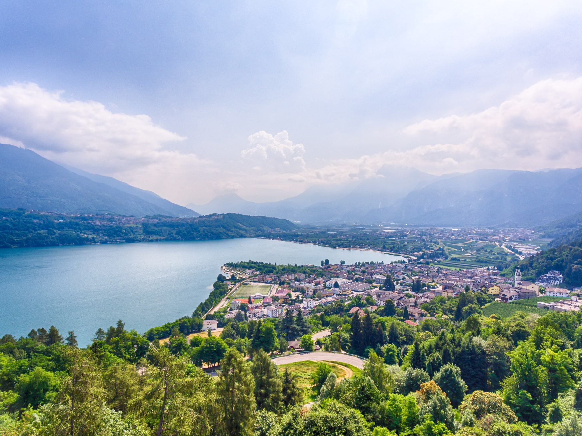 Panorama d'un lac avec un village et des montagnes.