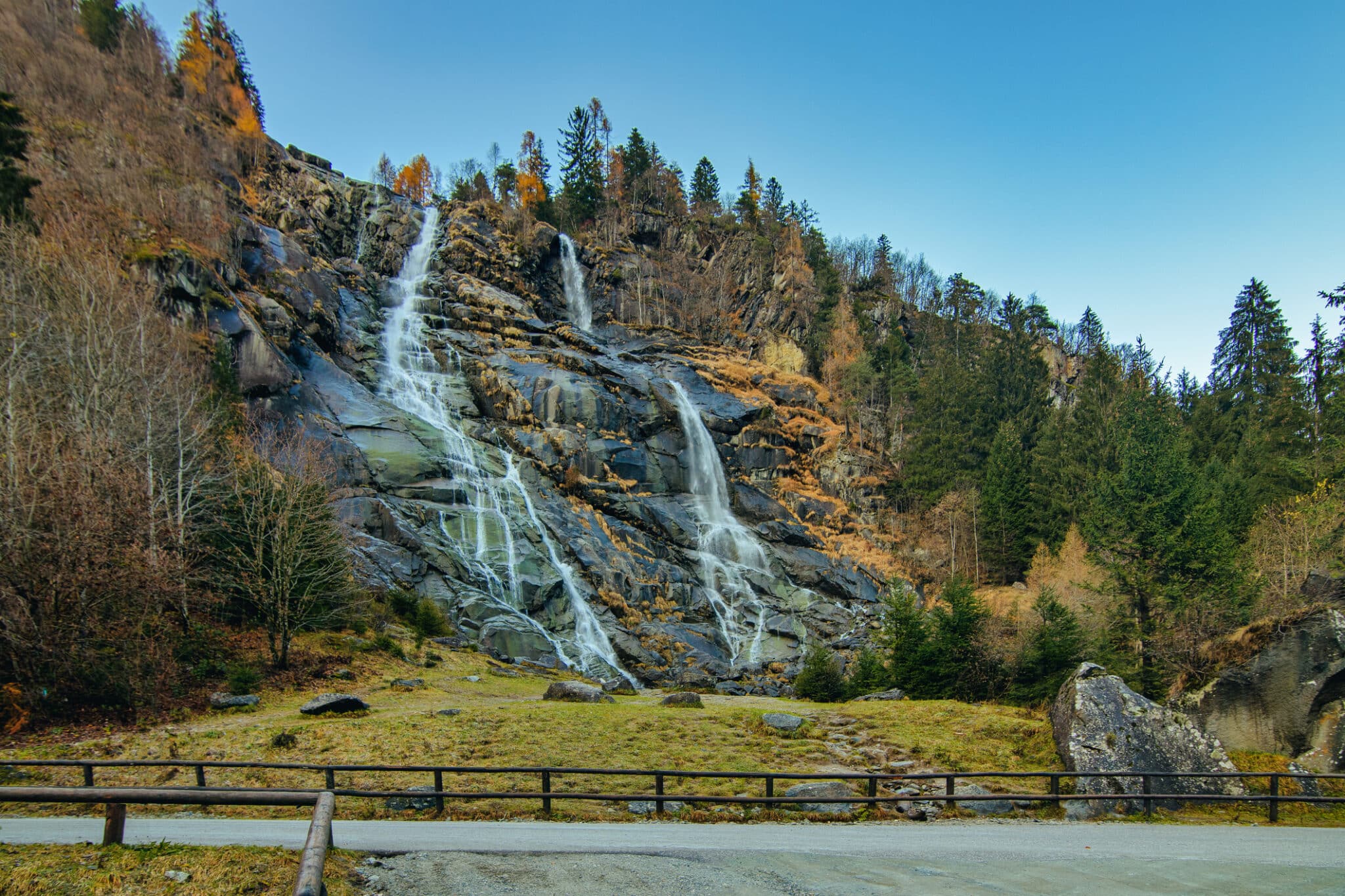 Wasserfall zwischen Wäldern und Felsen im Herbst