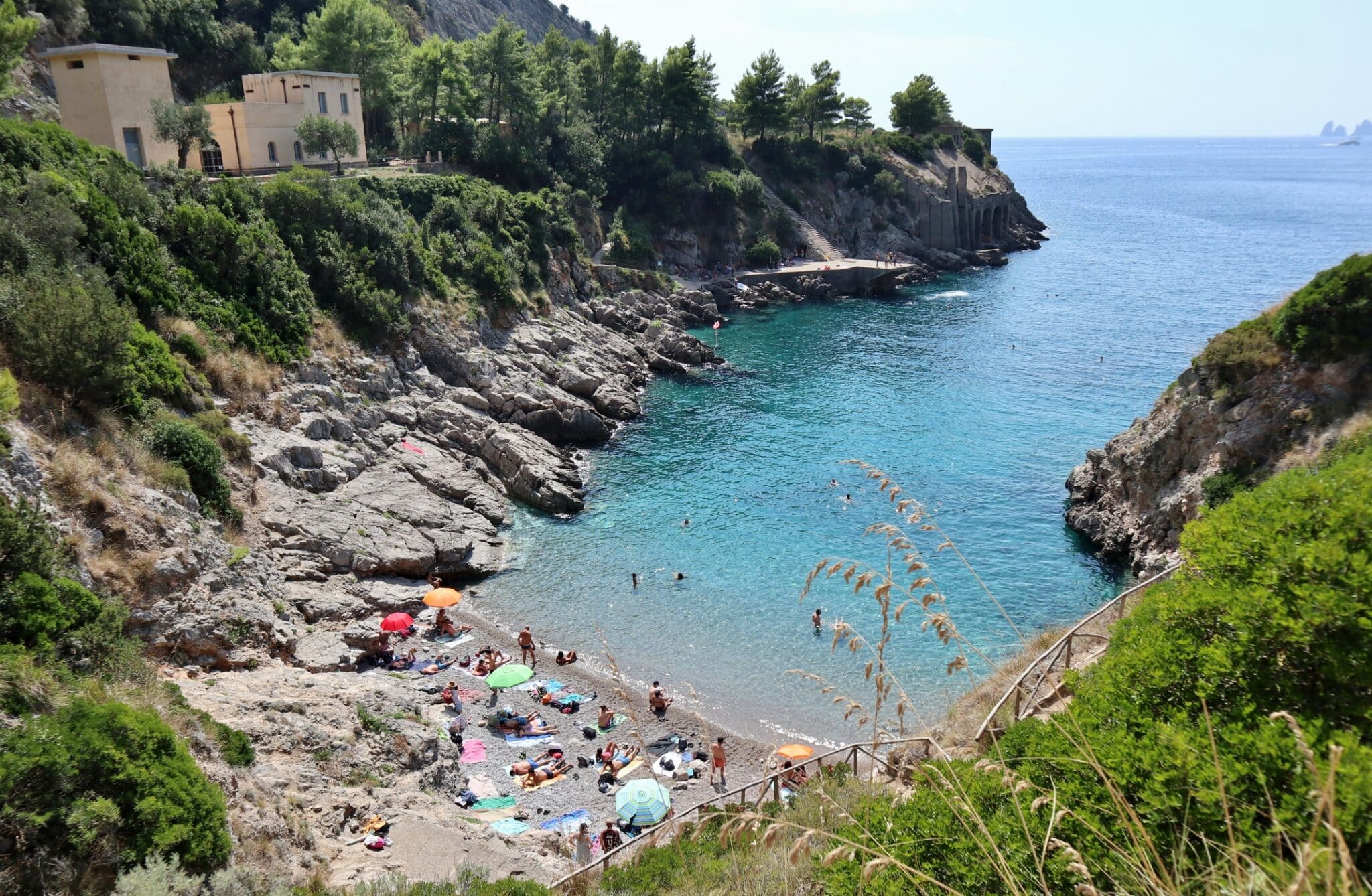 Rocky cove with people and parasols by the sea