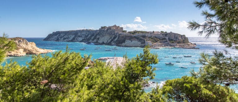 Felsige Küste mit Festung und Booten auf dem Meer