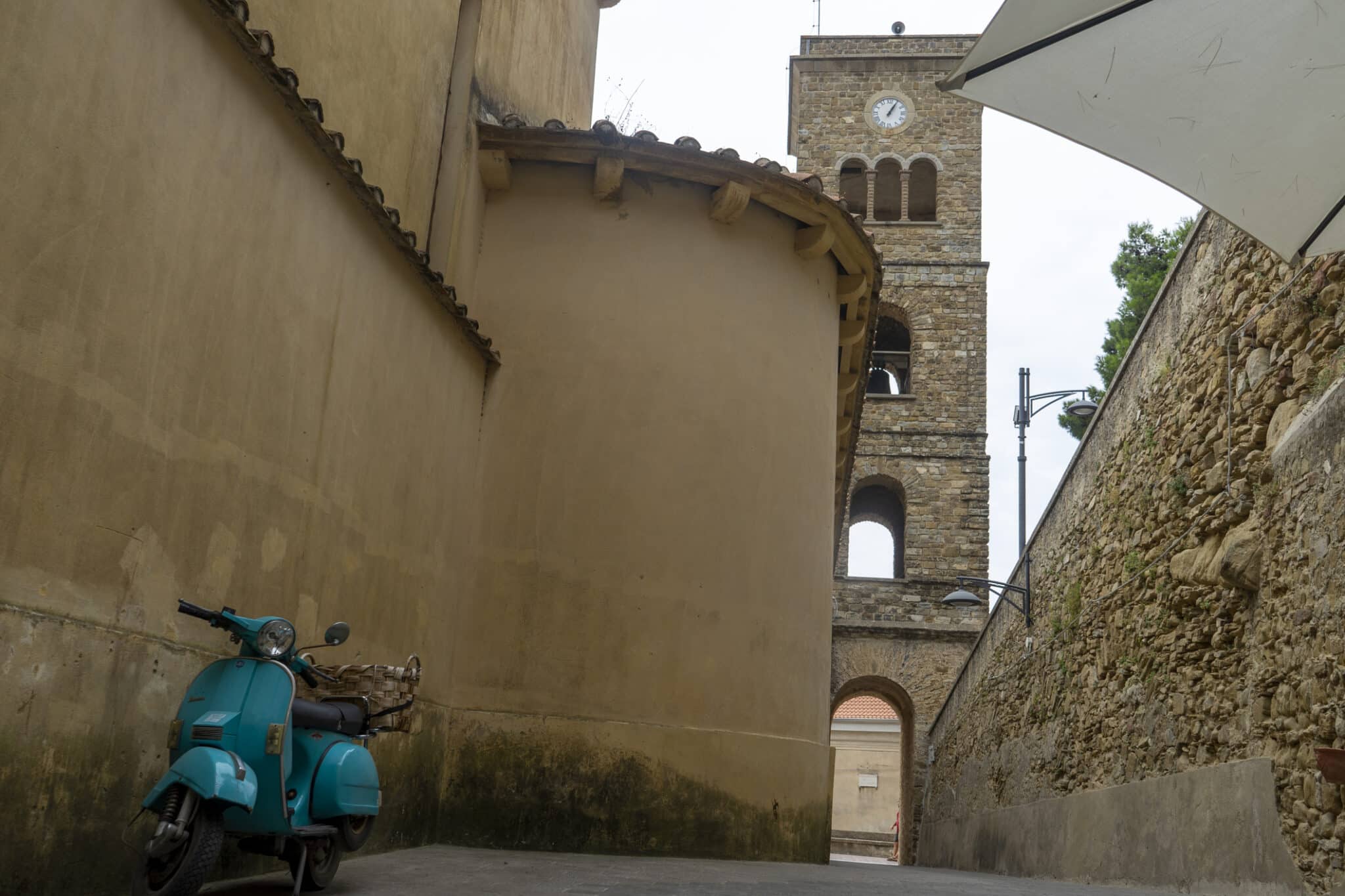 Vespa azzurra vicino chiesa storica italiana