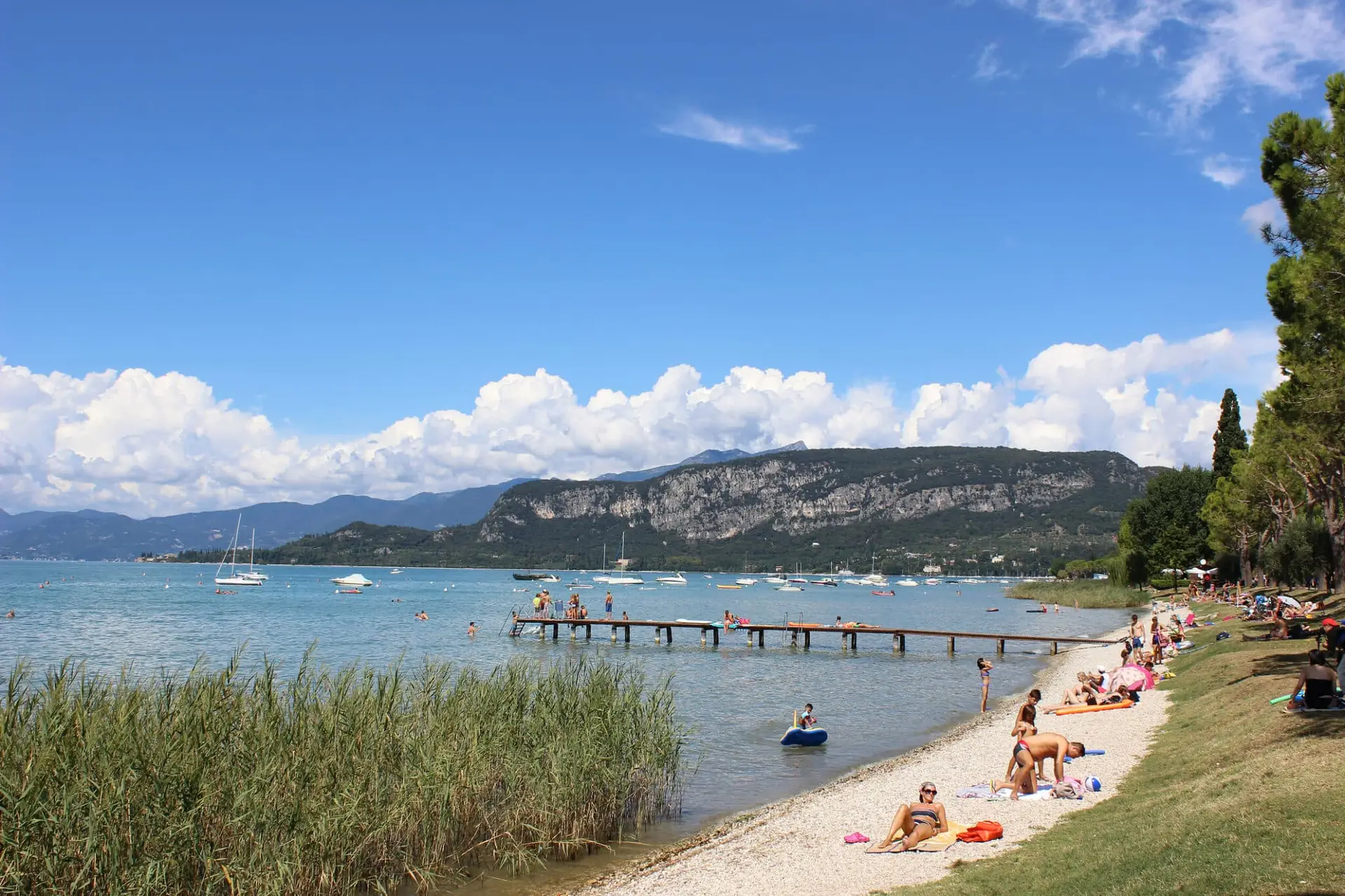 Spiaggia affollata con montagne sullo sfondo