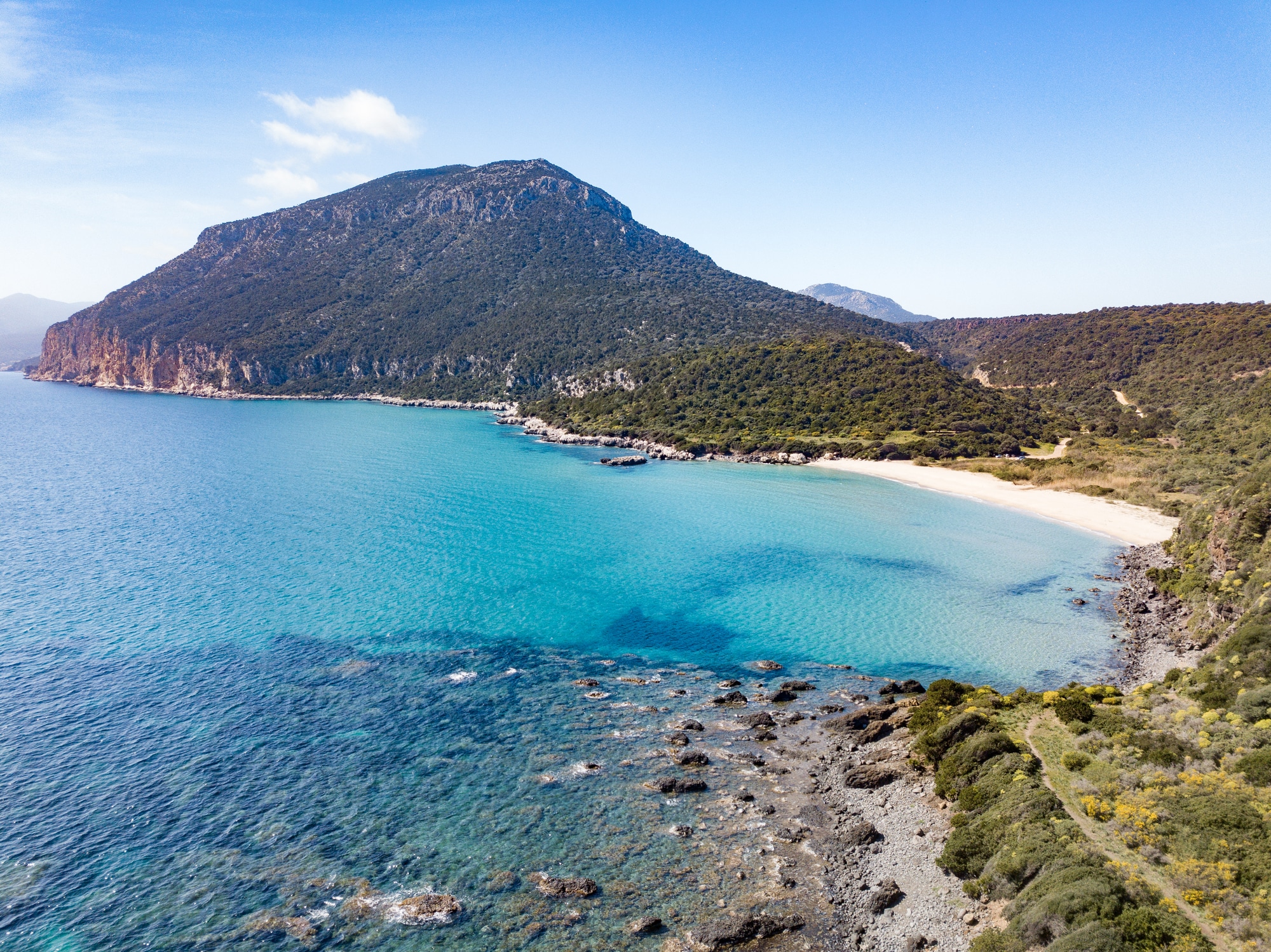 Plage vierge avec montagnes et mer cristalline